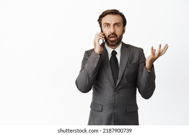 Businessman Talking On Mobile Phone With Confused Face, Dont Understand Caller, Standing Over White Background