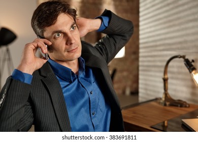 Businessman talking on mobilephone, looking away.