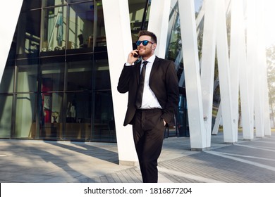 Businessman Talking on Phone Isolated. Business man Standing Full Length with Phone in Hand. Businessman on Sunny day wearing Sun Glasses talking on Phone - Shutterstock ID 1816877204