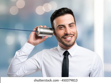 Businessman talking on a tin can phone