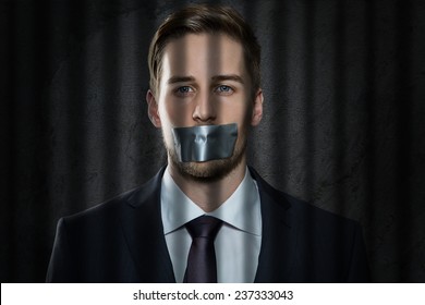 Businessman With Tape Over His Mouth