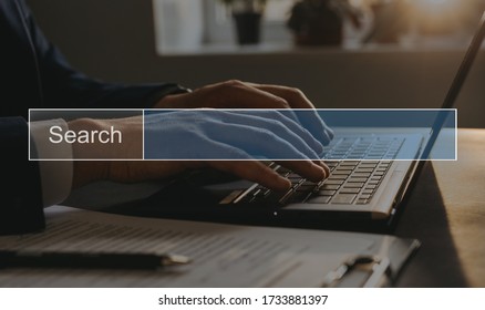 BusinessMan tapping laptop keyboard and search page on computer touch screen.SEO Concept Searching. Copy space.