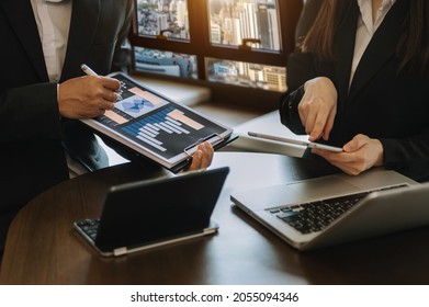 Businessman And Team Analyzing Financial Statement Finance Task. With Smart Phone And Laptop And  Tablet. Wealth Management Concept
