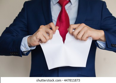 Businessman tearing blank paper apart on white background