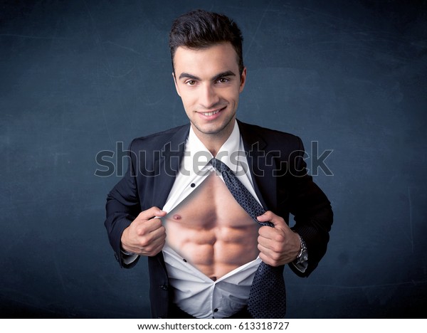 Businessman tearing off his shirt and showing\
mucular body concept on\
background