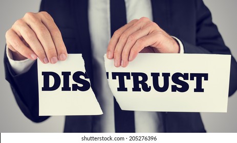 Businessman Tearing Up A Sign Saying - Distrust - Conceptual Image Importance Of Trust And Cooperation In Successful Business.