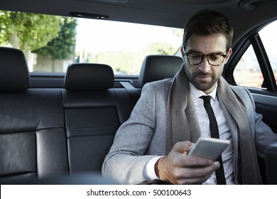 Businessman Texting On Smartphone In Car