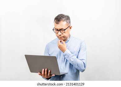 Businessman Thinking And Analyzing Business Growth From A Laptop Computer. Man Holding Notebook Computer And Use It. Concept For Finance, Business Operations, Real Estate, Technology, White Background