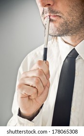 Businessman Thinking With Pencil In His Mouth. Portrait Of Thoughtful Business Person.