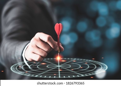 Businessman throwing red arrow dart to virtual target dart board. Setup objectives and target for business investment concept. - Shutterstock ID 1826793365