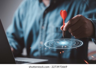 Businessman throwing red arrow dart to virtual target dart board, Setup objectives and target for business investment concept.
