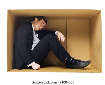 Businessman in a tight cardboard box isolated on white background