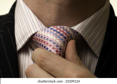 businessman tightens pink tie
