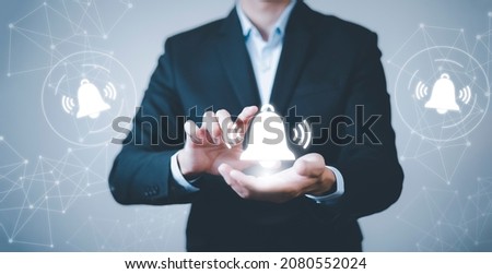 Businessman touch finger to press the button. Notification bell button on smartphone app screen close up,App Notification on Smart Phone Screen, Remote online alerts, home security signal.