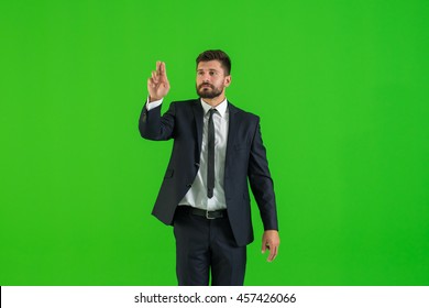 The businessman touch the virtual screen on the green background - Powered by Shutterstock