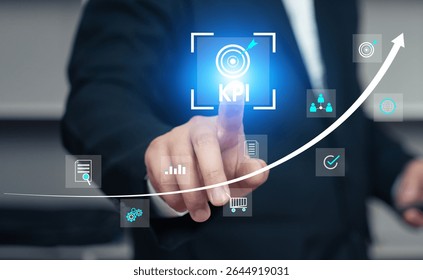Businessman touches a glowing KPI (Key Performance Indicator) icon on a virtual screen with various business and financial icons. A rising arrow graph in the background signifies performance improve.