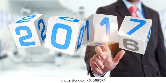 Businessman touching 2017 3D rendering text in dices with his finger
