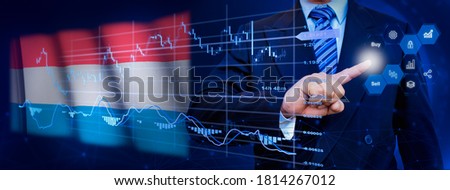 Businessman touching data analytics process system with KPI financial charts, dashboard of stock and marketing on virtual interface. With Luxembourg flag in background.