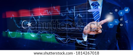 Businessman touching data analytics process system with KPI financial charts, dashboard of stock and marketing on virtual interface. With Libya flag in background.