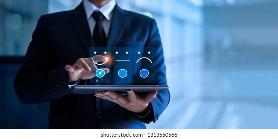 Businessman touching and drawing face emoticon smile on the tablet, service mind. blue background. Customer service concept. - Shutterstock ID 1313550566