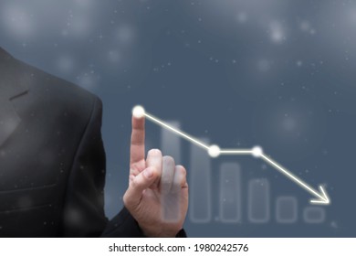 Businessman touching dropping diagram graph. Economy going down. Falling prices, bankruptcy, crisis concept. Blurred defocused view - Shutterstock ID 1980242576