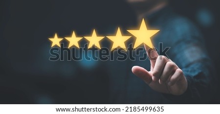 Businessman touching glowing yellow five stars for excellent evaluate after customer use product service , ISO and quality standard certificate concept.