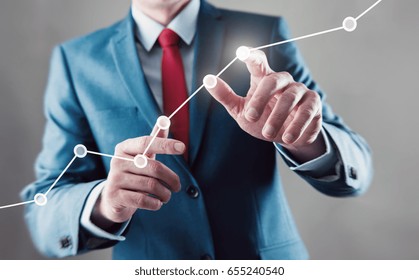 Businessman touching a growing graph