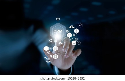 Businessman touching icon CRM on modern virtual interface. Customer relationship management (CRM) concept. 