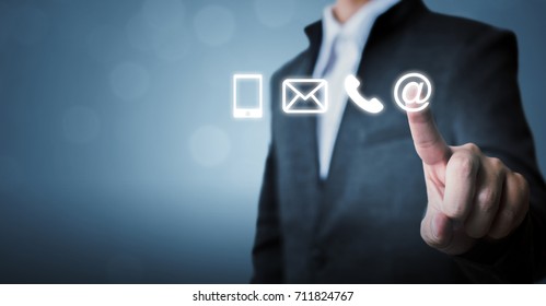 Businessman touching icon mobile phone, mail, telephone and address. Customer service call center contact us concept - Shutterstock ID 711824767