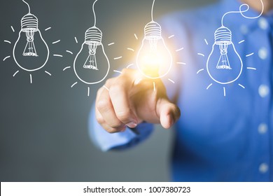Businessman touching light bulbs, new ideas with innovative technology and creativity.