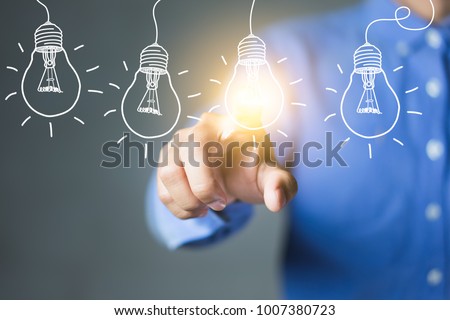 Businessman touching light bulbs, new ideas with innovative technology and creativity.