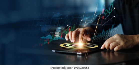 Businessman touching pie chart on tablet and analyzing sales data and economic growth graph chart. Financial. Stock market and banking on dark background.