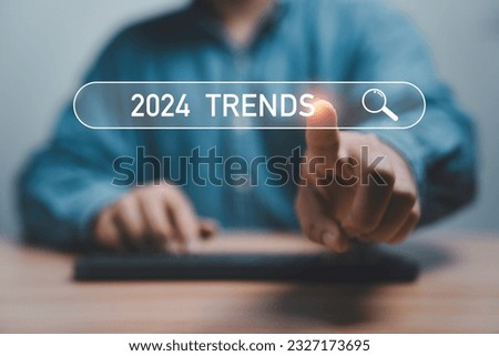Businessman touching to search engine bar with 2024 trends wording for marketing monitor and business planing in new year concept.
