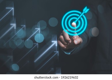 Businessman touching virtual dartboard with arrow ,Business Achievement objective target concept. - Shutterstock ID 1926219632