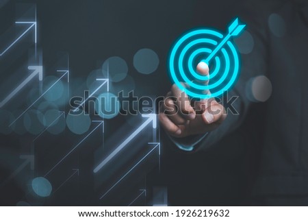 Businessman touching virtual dartboard with arrow ,Business Achievement objective target concept.