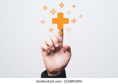 Businessman touching virtual orange plus sign for positive thinking mindset or healthcare insurance symbol concept.