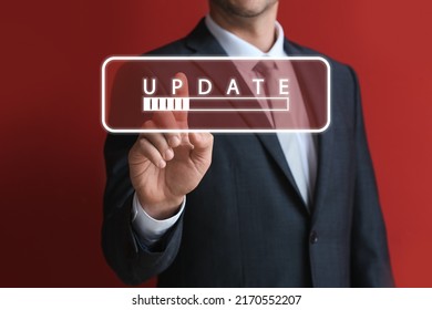 Businessman touching virtual screen with word UPDATE and status bar on red background - Shutterstock ID 2170552207