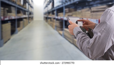 Businessman With Touchscreen Tablet Checking Inventory In Stock Room. Store House Inspection