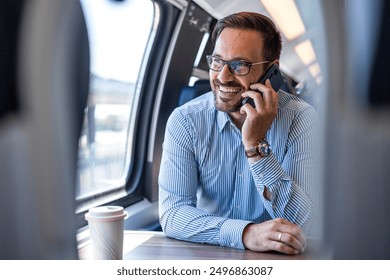 Businessman in train. Businessman working and traveling by train. He is using his smart phone. Young businessman talking by mobile phone in the train - Powered by Shutterstock