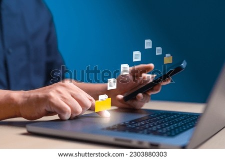 Businessman transfer data or document between phone to laptop computer on internet or network. Data file sent or Backup data, Exchange file on folder, DMS. Virtual document loading to another folder.