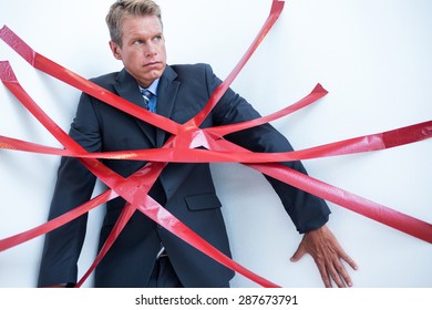 Businessman Trapped By Red Tape On White Background