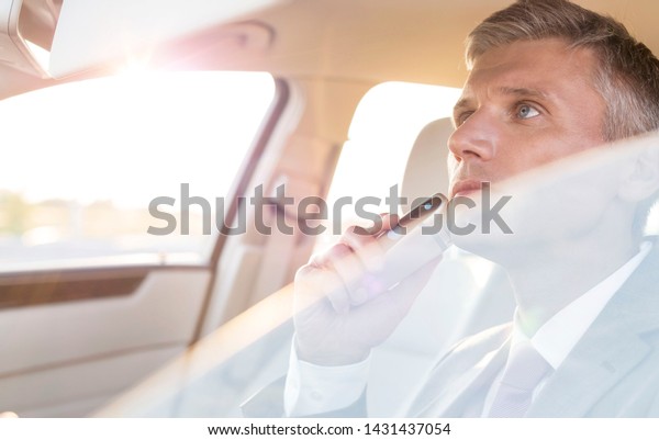 Businessman\
trimming while looking at mirror in\
car