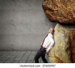 businessman try to move huge stones
