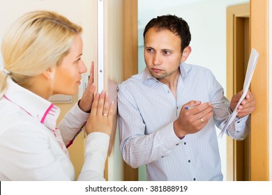 Businessman Trying To Collect Money From Housewife At Home Door