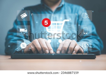 Businessman typing to computer keyboard with virtual shopping trolley cart and e-commerce icons such as credit cart, delivery truck ,sale percentage for online shopping concept.