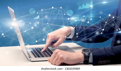 Businessman typing on laptop with linked reports charts grapghs around - Shutterstock ID 1302039889