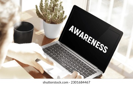 Businessman typing text Awareness in laptop on office background - Powered by Shutterstock