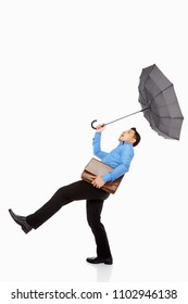 Businessman With Umbrella And Briefcase Being Blown Away