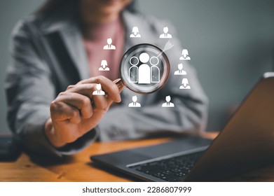 Businessman use magnifying glass to find human icon for business CRM or Customer Relation Management and customer focus target group concept, social media. Digital marketing online. HRM, human manage. - Shutterstock ID 2286807999