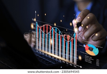 Businessman use pen tip to pointing the annual statistic on the business analytic dashboard.